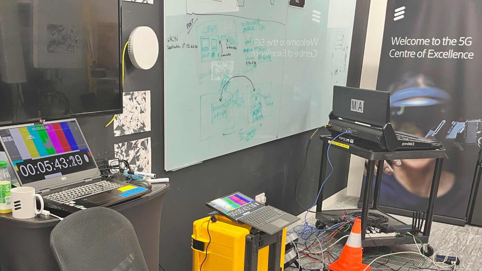 A photo of a lighting desk and laptops with time codes, R&D at Ericsson's 5G testbed